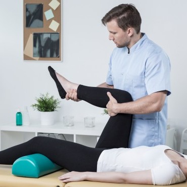 bigstock-Male-Physiotherapist-Exercisin-97075748.jpg